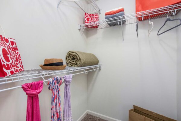 Village at Mission Farms apartment closet with built in wire shelves and clothing.