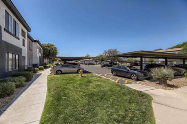 Villas at Mountain Vista Ranch apartments parking area with ample covered parking and lush lawns.