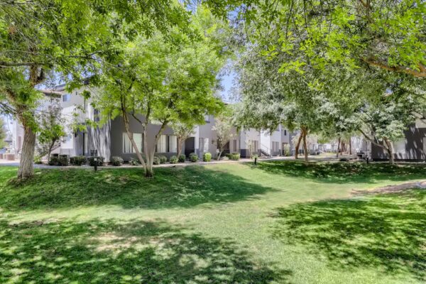 Villas at Mountain Vista Ranch apartments courtyard with lush green lawn and tall trees.