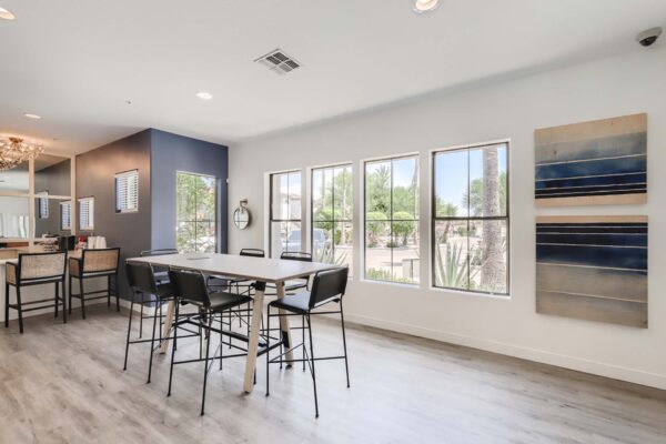 Villas at Mountain Vista Ranch apartments clubhouse with dining table, artwork, and large windows.