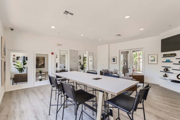 Villas at Mountain Vista Ranch apartments clubhouse with large dining table and stools.