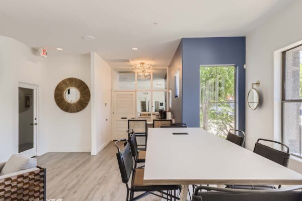 Villas at Mountain Vista Ranch apartments clubhouse with large dining table and large windows.