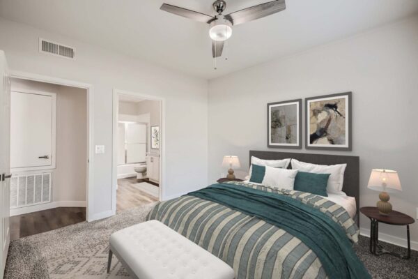 Villas at Mountain Vista Ranch apartment bedroom with carpet, plush bed with headboard, framed art, and ceiling fan.