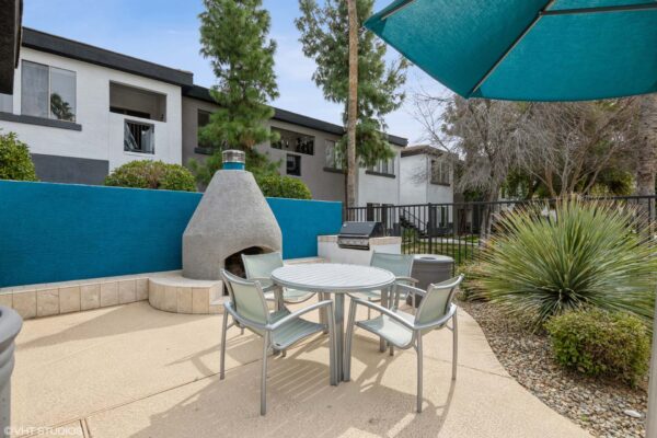 Villas at Mountain Vista Ranch apartments outdoor lounge with dining table, BBQ grill, and fire pit.