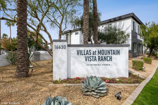 Villas at Mountain Vista Ranch apartments monument signage with lush desert landscaping.