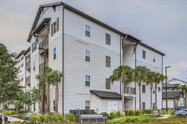 The Avery apartments exterior with classic architecture and tall palm trees.