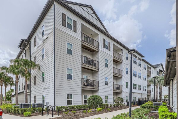 The Avery apartments exterior with classic architecture and tall palm trees.
