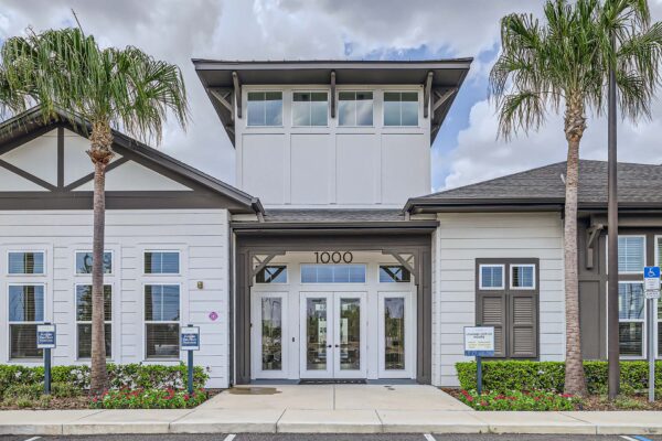 The Avery apartments clubhouse with lush landscaping and tall palms.