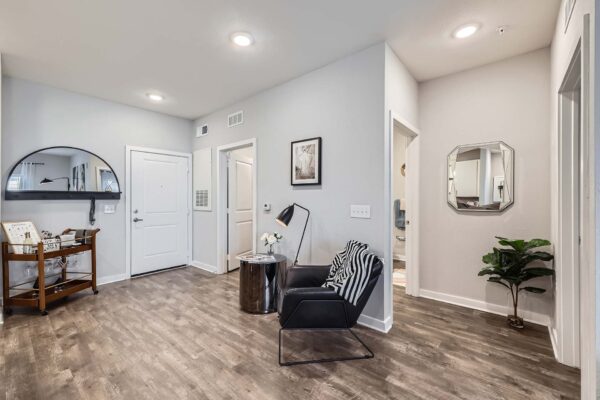 The Avery apartment living area with wood style floor, comfortable seating, and gray walls.