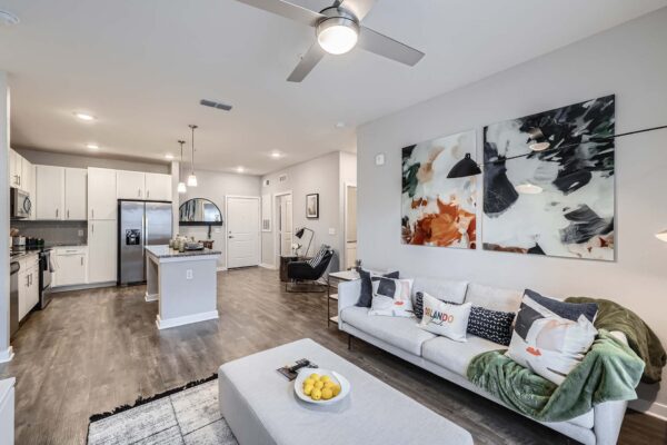 The Avery apartment living area with plush seating, modern kitchen, and large artwork.