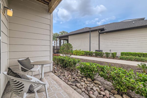 The Avery apartment balcony with outdoor seating and lush rocky landscaping.