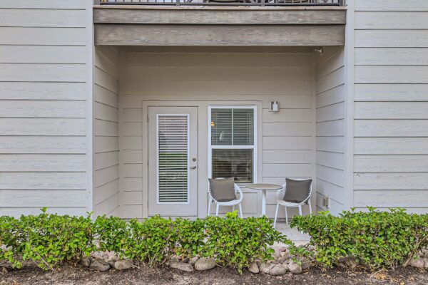 The Avery apartment balcony with outdoor seating and door to apartment.