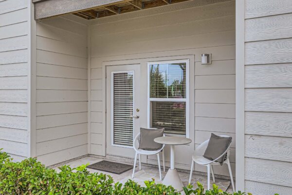 The Avery apartment balcony with outdoor seating and door to apartment.