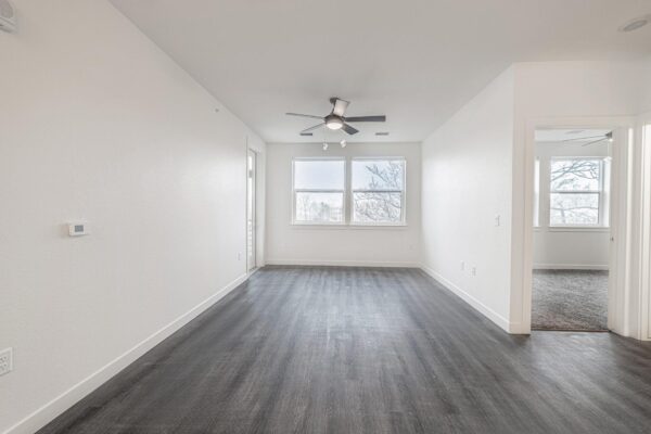 29x apartment living area with wood style floor, ceiling fan, and large windows.