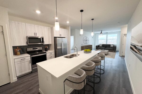 29x apartment living area with wood style floor, breakfast bar with stools, and plush living room.