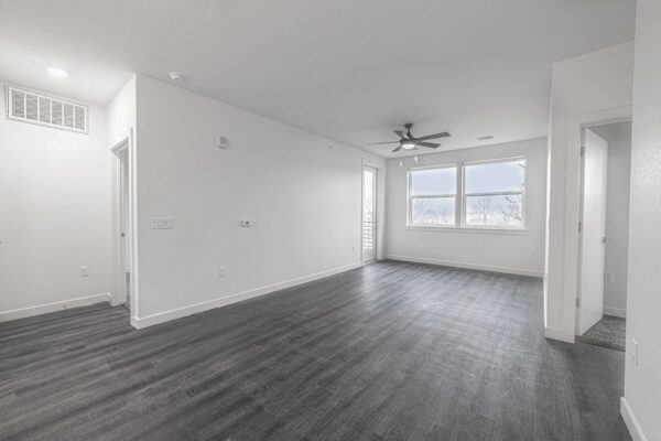 29x apartment living area with wood style floor, ceiling fan, and large windows.