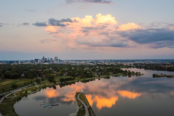 Aerial view of Denver, Colorado with large lake, distant skyline, and large clouds.
