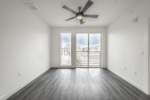 29x apartment living room with wood style floor, large windows, and ceiling fan.
