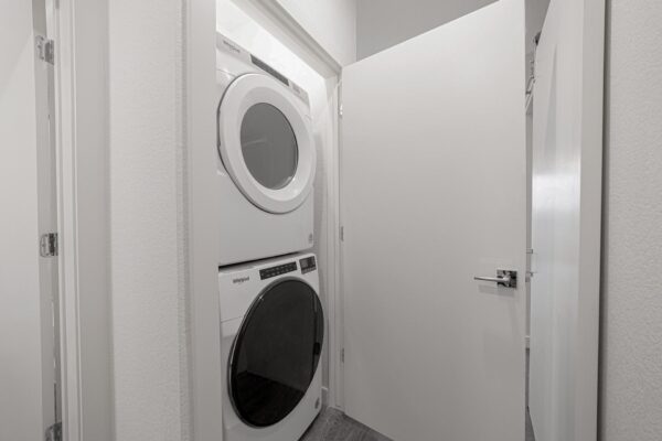 29x apartment laundry closet with stacked washer and dryer.