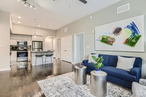 500 Ocean apartment living room with wood style floor, plush seating, framed artwork, and modern kitchen.