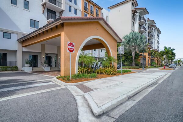 500 Ocean apartments entrance with lush landscaping and tall palm trees.