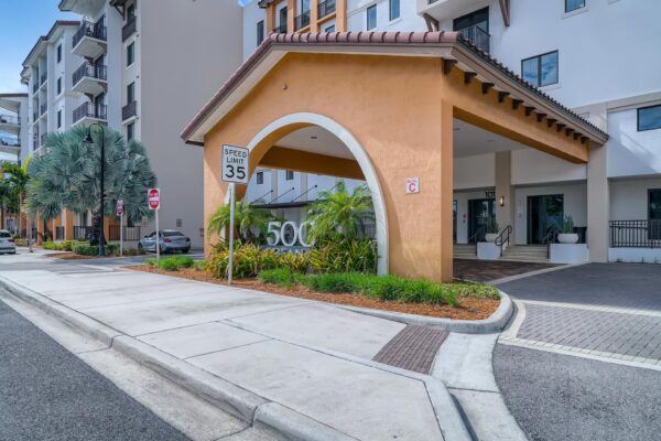 500 Ocean apartments entrance with lush landscaping and tall palms.