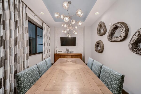 500 Ocean apartments business center with conference table, TV, and elegant decor.