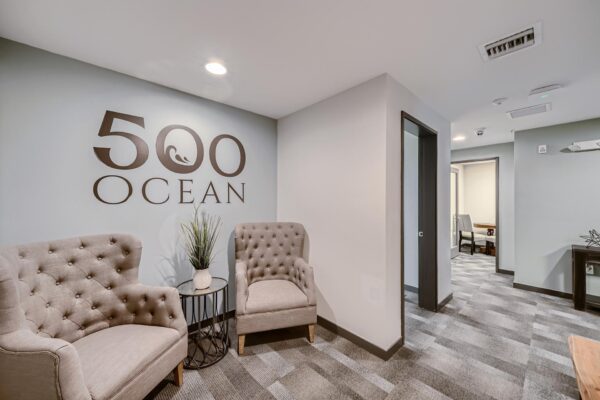 500 Ocean apartments office with plush chairs and wall signage.