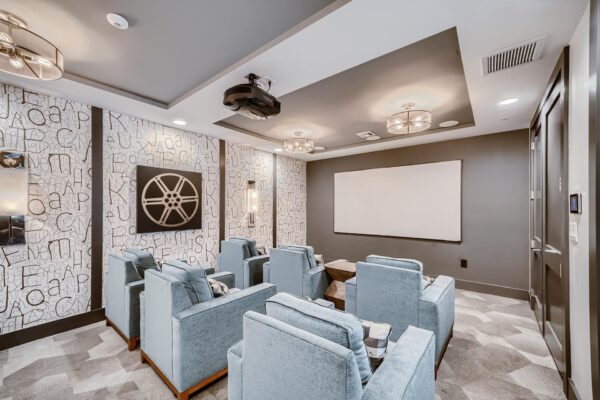 500 Ocean apartments theater room with plush chairs and projector screen.