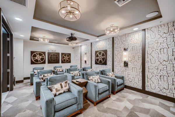 500 Ocean apartments theater with plush chairs and projector.