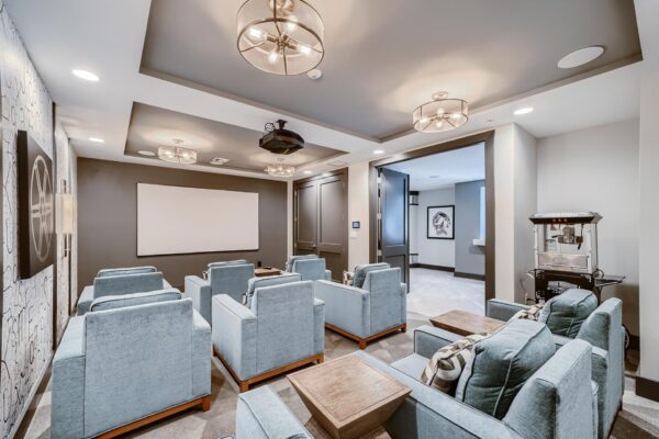 500 Ocean apartments theater with plush chairs, projector, and popcorn machine.