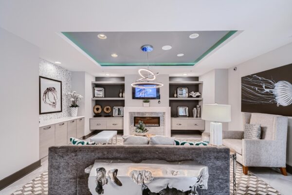 500 Ocean apartments common area with plush seating, elegant decor, fireplace, and TV.