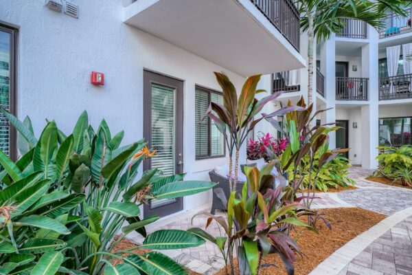 500 Ocean apartments courtyard patio with lush landscaping and stone paver walkways.