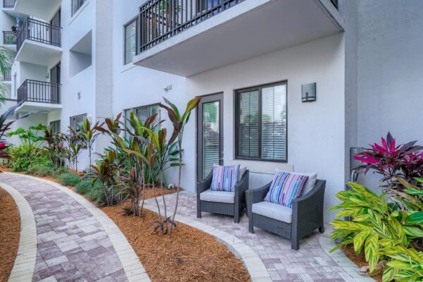 500 Ocean apartments patio with lush landscaping and stone paver walkways.
