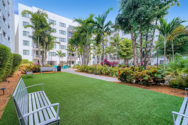 500 Ocean apartments outdoor lounge with green lawns, lush landscaping, and ample seating.