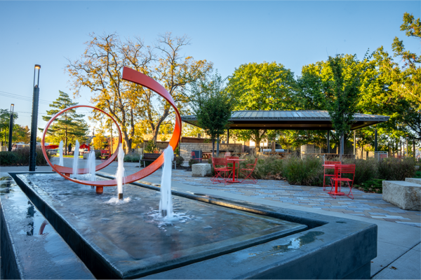 Sculptural artwork with fountains and outdoor seating.