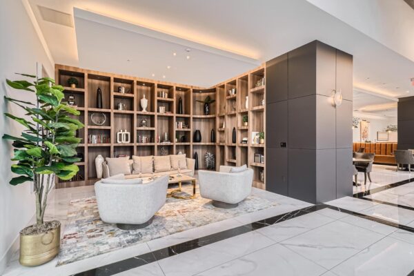 Arte Grand Central apartments resident lounge with plush seating and shelves with decor.