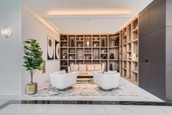 Arte Grand Central apartments resident lounge with plush seating and shelves with decor.