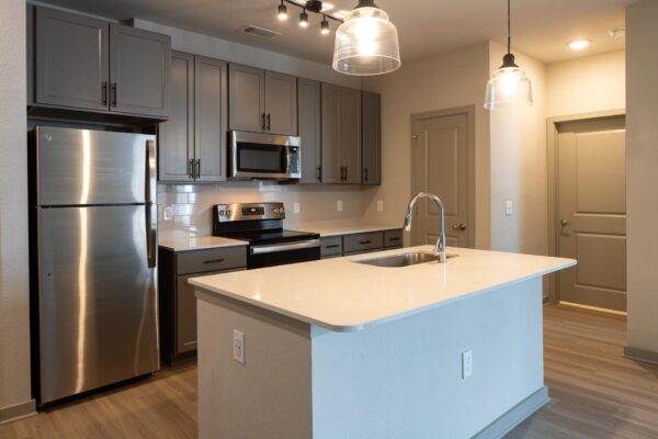 Arte St. Pete apartments kitchen with stainless steel appliances, backsplash, and wood-style floors.