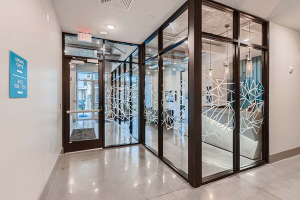 Arte St. Pete apartments lobby with glass walls and concrete floors.