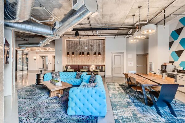 Arte St. Pete apartments lounge with plush blue couch and dining table.