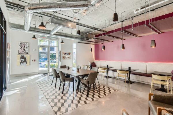 Arte St. Pete apartments lounge with dining tables and booths.