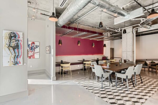 Arte St. Pete apartments lounge with dining tables and booths.
