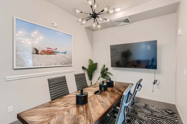 Arte St. Pete apartments conference room with table, chairs, and TV.