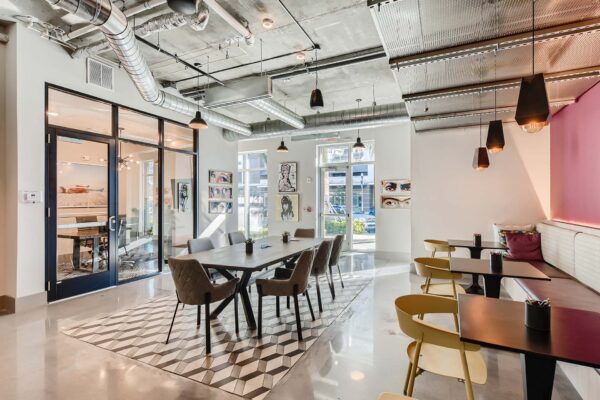 Arte St. Pete apartments lounge with dining table and booths.