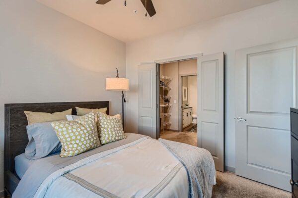 Arte St. Pete apartment bedroom with carpet, plush bed, and large closet door.