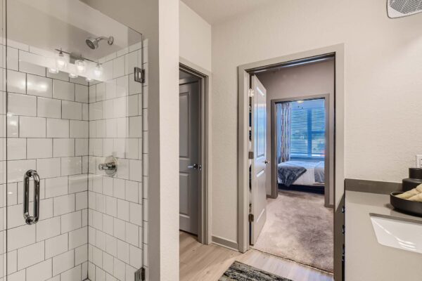 Arte St. Pete apartment bathroom with tiled glass wall shower.
