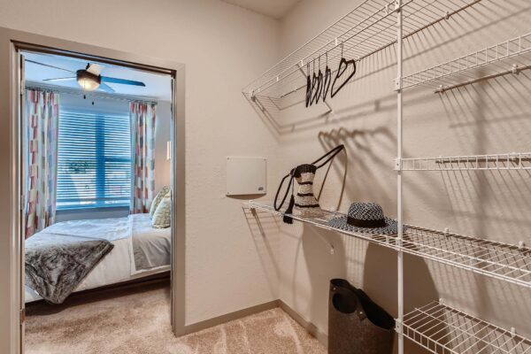 Arte St. Pete apartment closet with built in shelves and clothes.