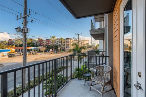 Arte St. Pete apartment balcony with outdoor chair and lush landscaping.