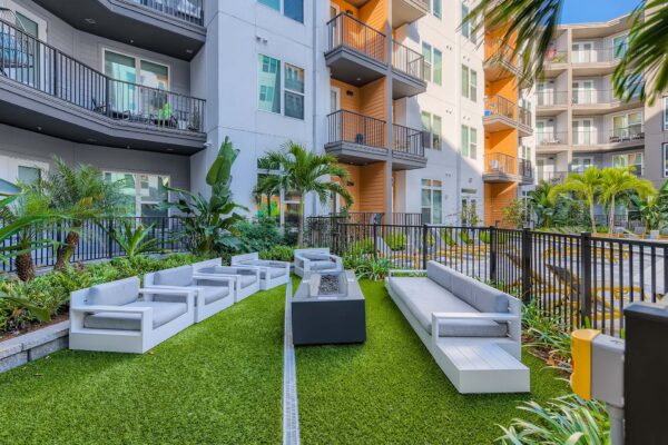 Arte St. Pete apartments pool area with plush seating and fire pit.